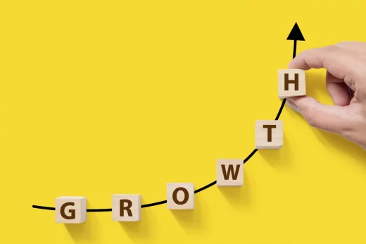 Wooden cubes on a yellow background with the word GROWTH