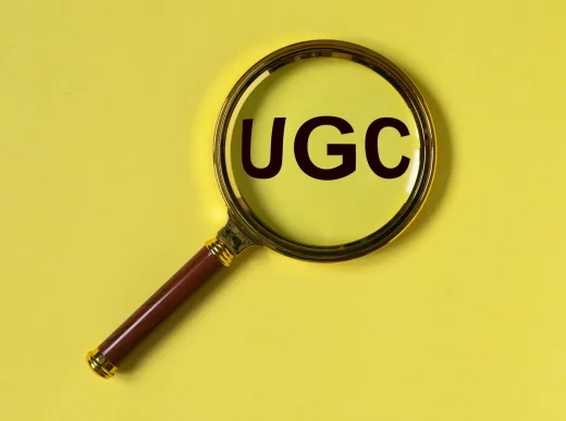 UGS or User-generated content acronym for social media on yellow background with loupe