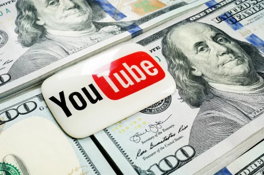 YouTube logo lies on the wads of money