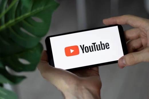 Smartphone screen YouTube logo with in human hands