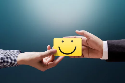 happy customer woman giving feedback with Happy Smiley Face Card in businessman's hand