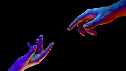 Hands reaching out, pointing finger together on black and neon colorful light