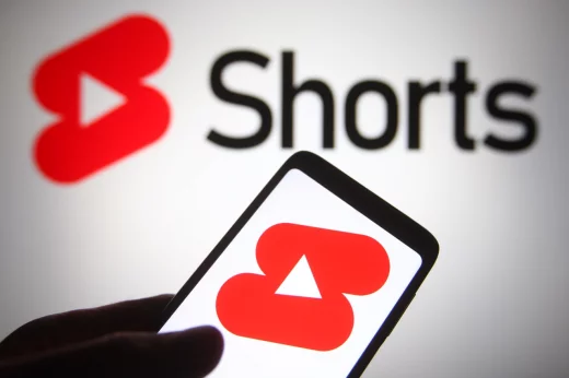 YouTube Shorts logo is seen on a mobile phone and a computer screen