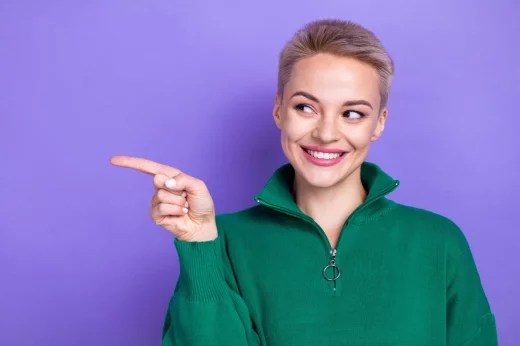 Smiling girl in green jumper on purple background