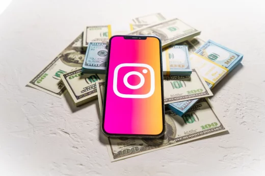 Money and smartphone displaying the Instagram logo