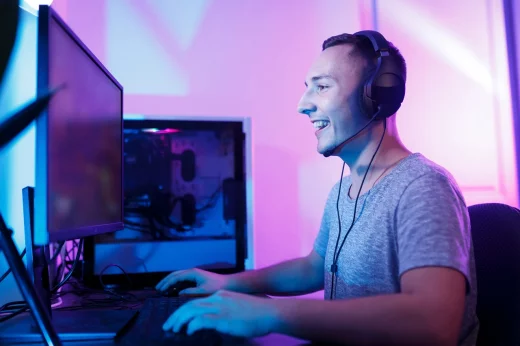 Happy male gamer enjoys playing computer games