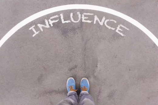 Influence text on asphalt ground, feet and shoes on floor, personal perspective footsie concept